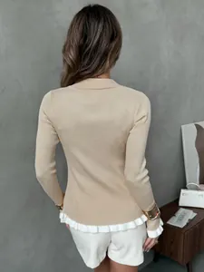 Back view of beige ribbed knit sweater with elegant white ruffled hem and collar detail.