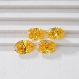 Gros plan de quatre diamants de synthèse jaunes de taille ovale sur blanc