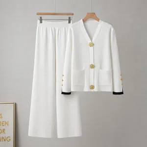 Détail de l'ensemble deux pièces en tricot blanc avec boutons dorés et bordure