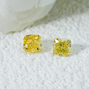 Primer plano detallado de dos diamantes amarillos sintéticos con talla cojín y fuego