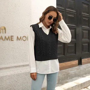 Débardeur en maille torsadée noire porté sur une chemise blanche et un jean bleu.