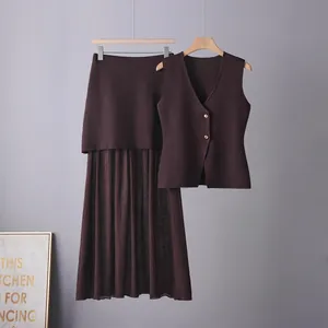 Detail shot of elegant burgundy women's knit vest and matching pleated skirt set