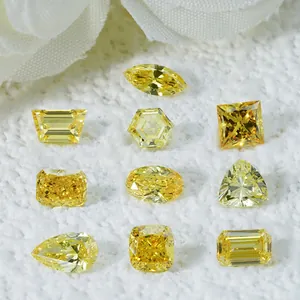 Primer plano de varios diamantes amarillos creados en laboratorio sobre fondo blanco.