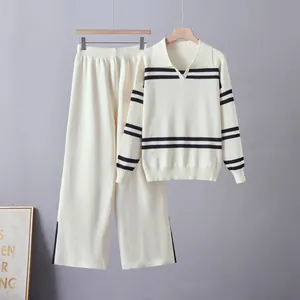 Detailed shot of women's white striped knit sweater and matching pants set.