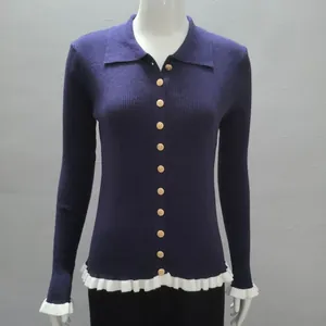 Close-up detail of a navy blue ribbed knit cardigan featuring gold buttons and ruffle trim