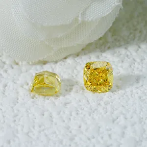 Par de diamantes de laboratorio amarillos talla cojín sobre piedra blanca texturizada
