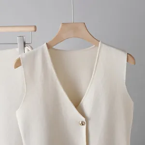 Close-up view showing the fine texture of cream knitted V-neck vest with gold button