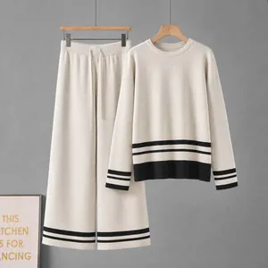 Elegante conjunto de punto de dos piezas con jersey crema y pantalón a rayas negras