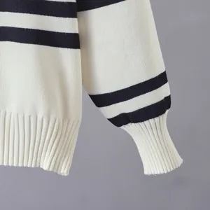 Detail view of cream and navy striped knit sweater showing ribbed cuff and hem texture.
