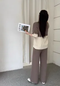 Rückansicht eines zweiteiligen Stricksets mit Spitzen-Patchwork und Hose mit weitem Bein.