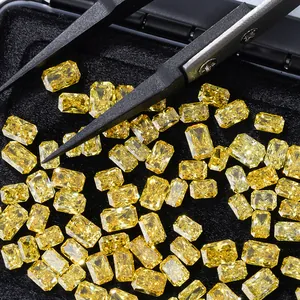 Loose radiant cut lab-grown yellow diamonds displayed in a black box with precision tweezers