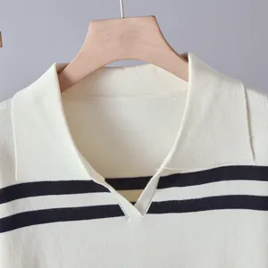Close-up detail of the elegant striped lapel and V-neck collar on a white knit top