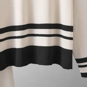 Detalle del tejido de punto con rayas blancas y negras de un jersey casual para mujer.