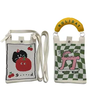 Detailed view of cute knitted mini bags with embroidered cartoon characters and padded handle