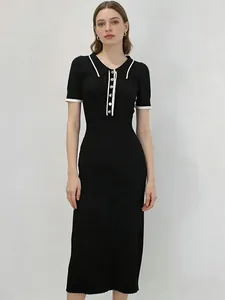 Robe longue en maille noire élégante avec col contrasté blanc et boutons dorés.