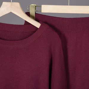 Detail shot of burgundy knit sweater and skirt set with fine texture on hangers