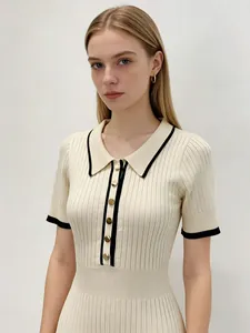 Détail de la robe en maille à boutonnage simple avec col noir contrasté et boutons dorés