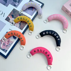 Colorful embroidered crescent bag charms with 'HOLIDAY' text in ins-style layout.
