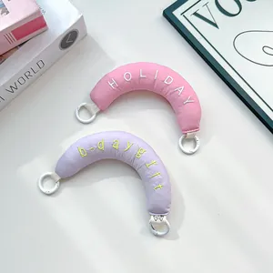 Detail view of cute pink and lilac embroidered padded curved bag handles with white rings.