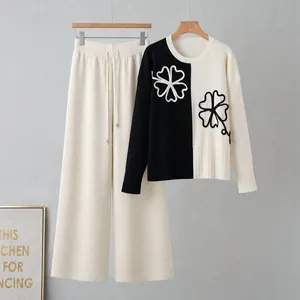 Two-piece knit set featuring color-block sweater and matching wide-leg pants.