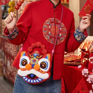 Detailed view of a cute lion dance plush bag with intricate embroidery on red fabric.