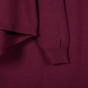 Close-up detail of the ribbed cuff and hem texture on a burgundy knitted women's sweater.