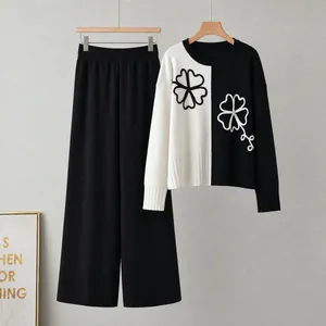 Detail view of a black and white color-block knitted sweater and wide-leg pants two-piece set