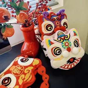 Close-up detail view of cute plush lion dance bags featuring traditional Chinese embroidery