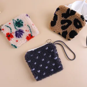 Plush sherpa wristlet pouches with floral, leopard, and polka dot patterns in detail
