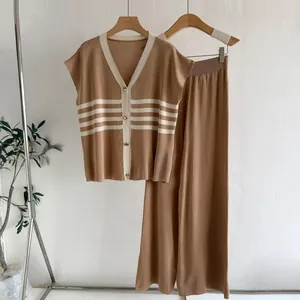 Detailaufnahme eines camelfarbenen Stricksets mit gestreifter Strickjacke und weiter Hose.