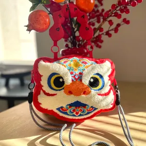 Detailed view of a plush lion dance head crossbody bag with textured embroidery