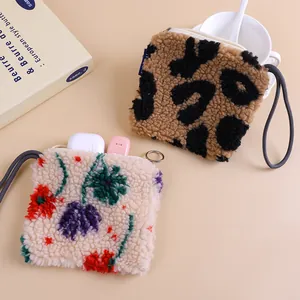 Macro view of plush lamb wool coin pouches featuring leopard and floral patterns.