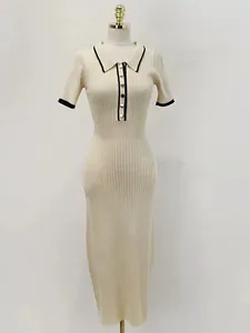 Gros plan sur la robe en maille côtelée avec son col polo contrasté et ses boutons dorés.