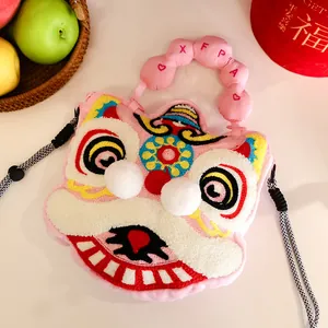 Detail shot of a pink plush lion dance head handbag with cute pom-poms and embroidery.