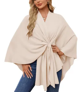 Détail d'un élégant poncho châle en tricot de couleur crème pour femme sur un mannequin