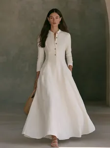 Elegant white long-sleeved linen maxi dress with stand collar and button-down front