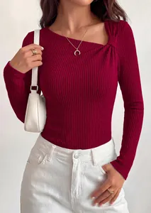 Close-up detail of burgundy ribbed knit top featuring an asymmetrical knot neckline
