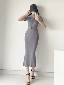 Full body view of an elegant grey ribbed knit polo midi dress with a mermaid hemline