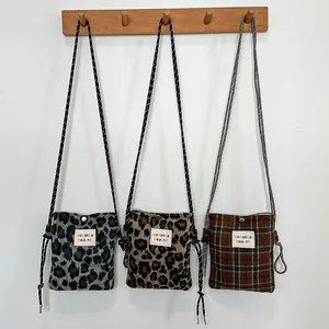 Detailed view of three small fuzzy crossbody bags in leopard and plaid patterns.