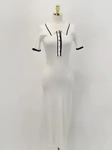 Vue détaillée d'une robe en tricot blanche avec bordures contrastées noires et boutons