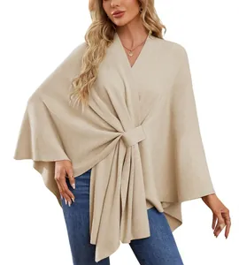 Gros plan sur l'élégant poncho en tricot beige avec un design froncé unique à l'avant