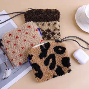 Close-up of three stylish faux lamb wool mini bags with leopard and heart patterns.