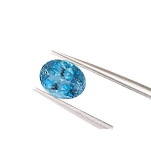 Zaffiro blu Paraiba sintetico di alta qualità taglio ovale tenuto da una pinzetta in metallo