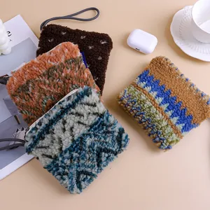 Detail view of four colorful plush sherpa coin purses in a cozy winter lifestyle setting