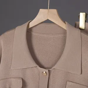 Primer plano del cárdigan de punto beige con solapa francesa y detalle de botón dorado