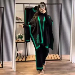 Detailansicht des schwarz-grün gestrickten Dreiteilers mit Schal und weiter Hose für Damen.