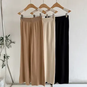 Damen-Strickhosen mit weitem Bein in Khaki, Creme und Schwarz an Holzkleiderbügeln