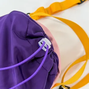 Vue détaillée du cordon de serrage violet sur le sac bandoulière pour bouteille d'eau