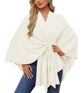Détail d'un châle en tricot crème élégant avec un design de nœud avant sophistiqué