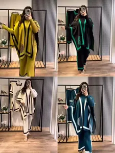 Detailansicht des farbblock-gestrickten 3-teiligen Sets mit Poncho und weiten Hosen